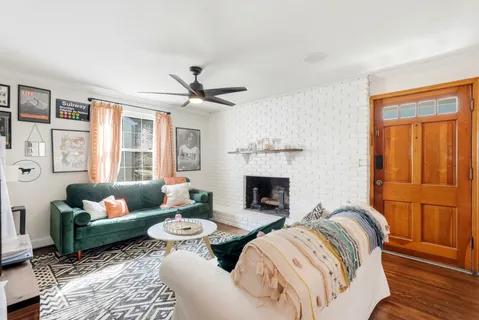 a living room with furniture fireplace and a large window