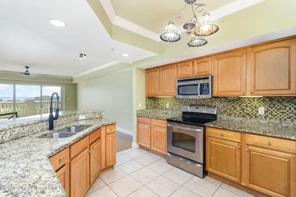 a kitchen with stainless steel appliances granite countertop a sink and stove top oven with granite countertops