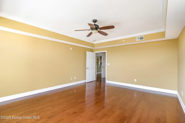 a view of an empty room with wooden floor