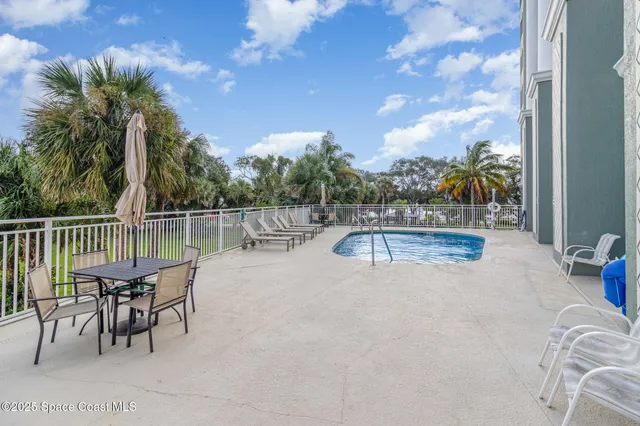 a view of a swimming pool with a patio and a yard