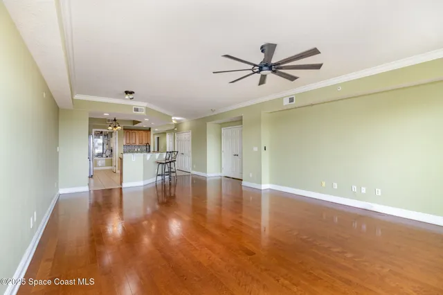 a view of empty room with wooden floor and window