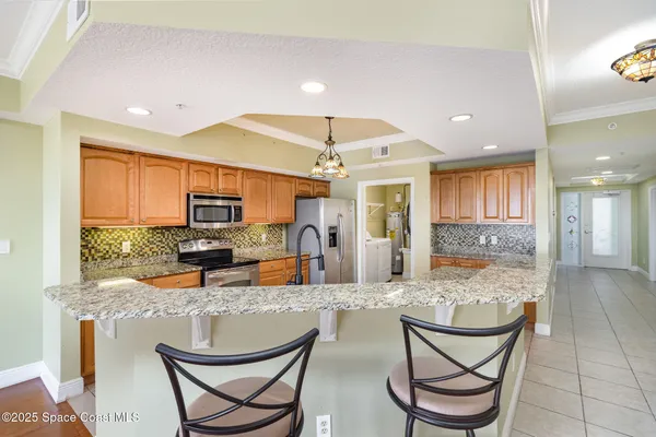 a kitchen with a dining table chairs cabinets and stainless steel appliances