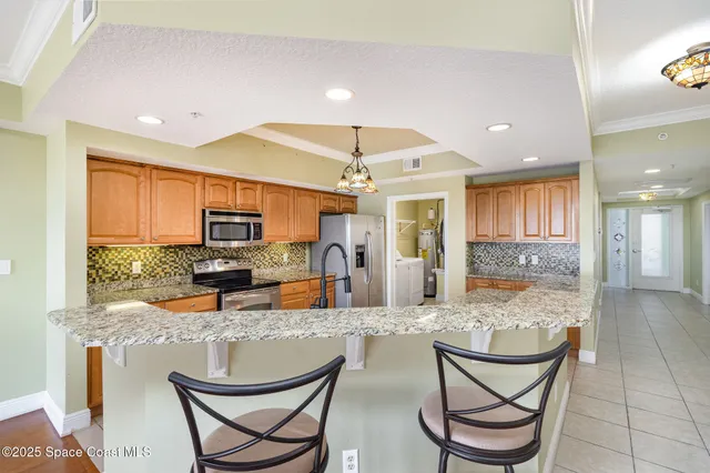 a kitchen with a dining table chairs cabinets and stainless steel appliances