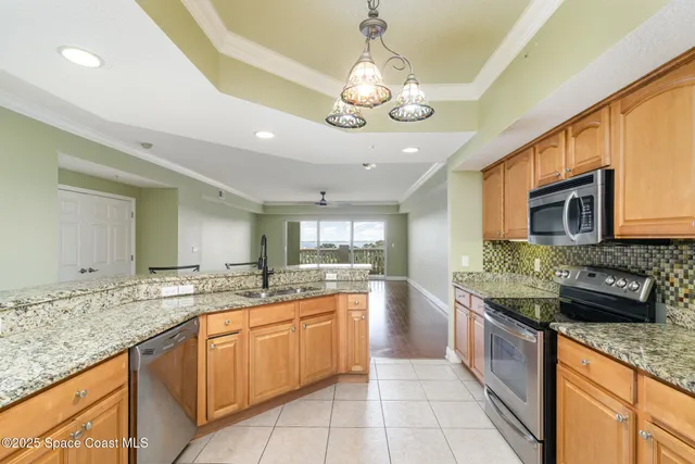 a large kitchen with stainless steel appliances granite countertop a sink and cabinets
