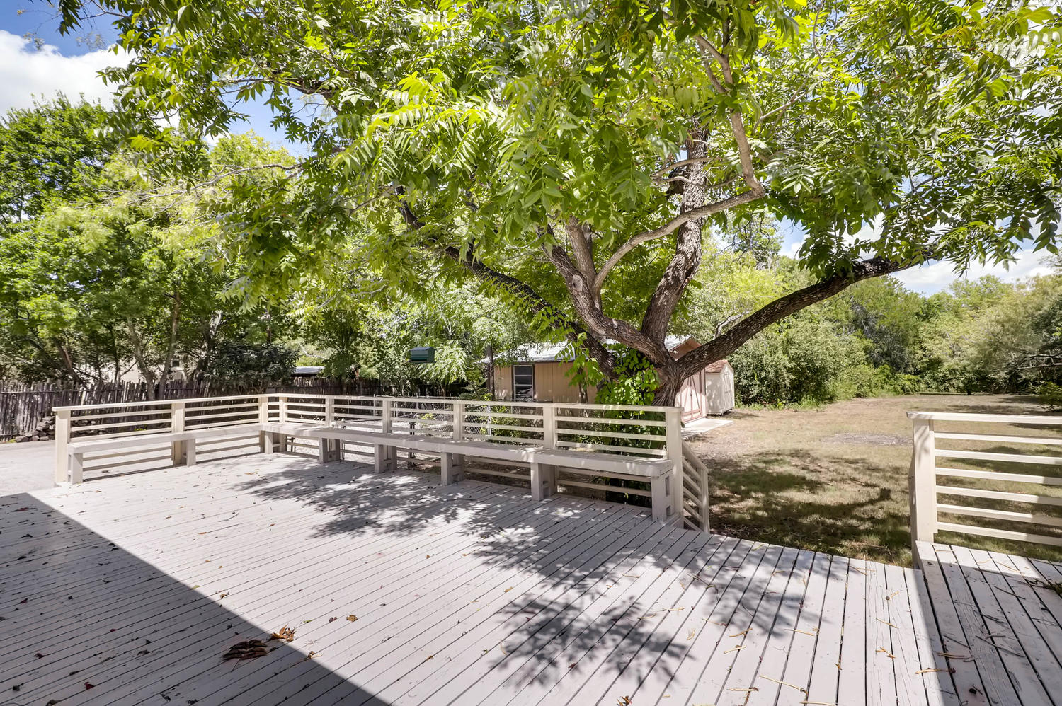446 Pike Road San Antonio, TX 78209 - Photo 23 of 28 Relax on the spacious wooden deck, shaded by a mature tree, overlooking a verdant yard.