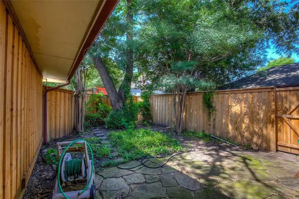 a view of a backyard with potted plants and large tree
