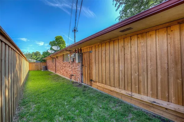 a view of a backyard with wooden fence and plants