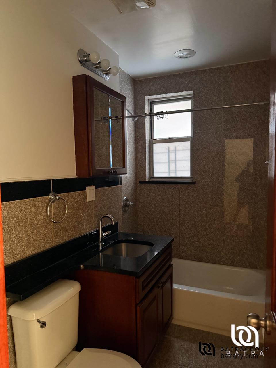 39-11 62nd Street, Unit 2 Queens, NY 11377 - Photo 4 of 7 a bathroom with a sink a bathtub and a shower
