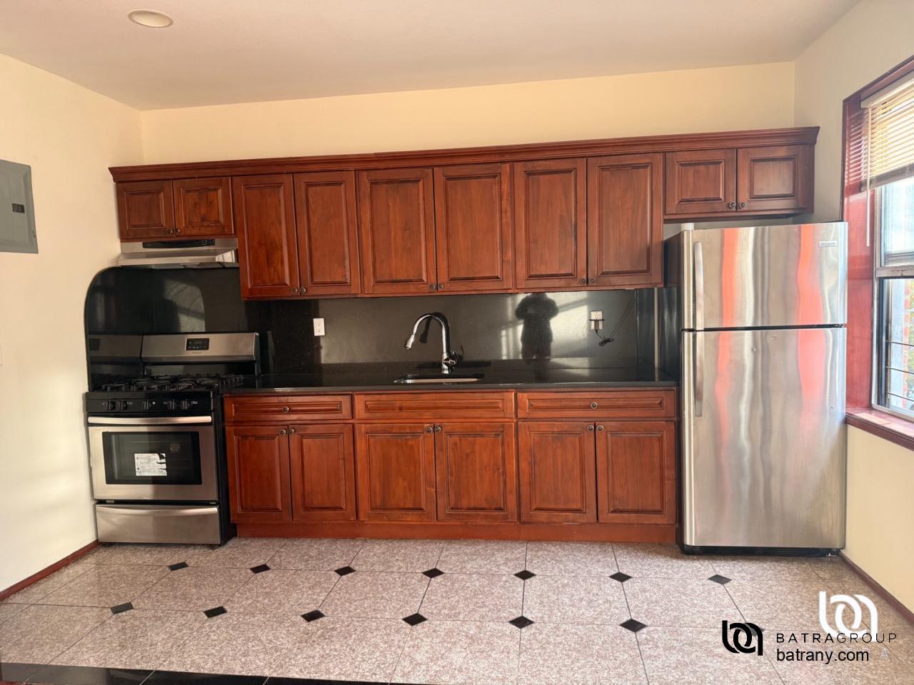 39-11 62nd Street, Unit 2 Queens, NY 11377 - Photo 7 of 7 a kitchen with stainless steel appliances granite countertop a refrigerator sink and stove