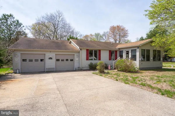 a front view of house with yard and trees in the background