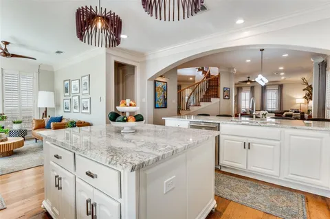 a kitchen with a sink dishwasher and a large mirror with wooden floor
