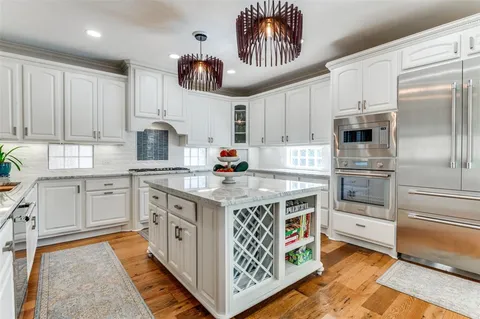 a kitchen with stainless steel appliances a stove a sink and a refrigerator