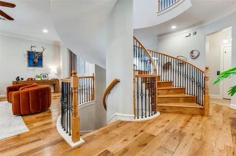 a view of a livingroom with wooden floor and stairs