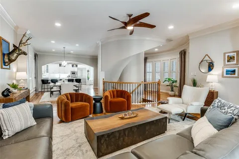 a living room with furniture kitchen view and a chandelier