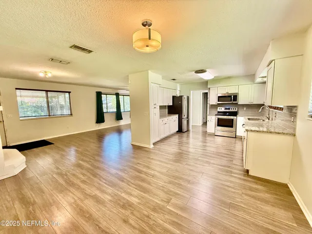 a view of kitchen with cabinets and wooden floor