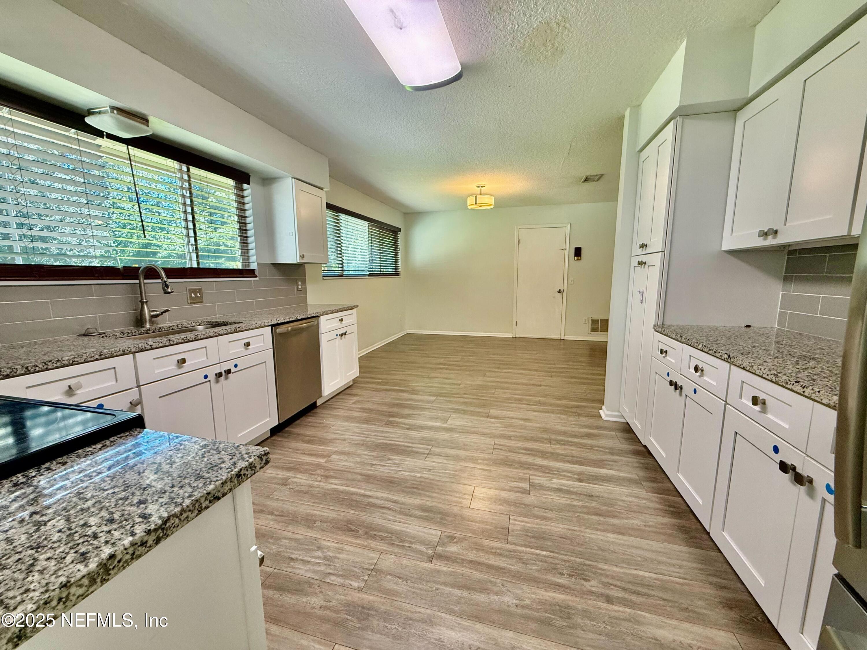 2349 Moody Avenue Orange Park, FL 32073 - Photo 4 of 10 a large kitchen with stainless steel appliances granite countertop a sink and cabinets with wooden floor