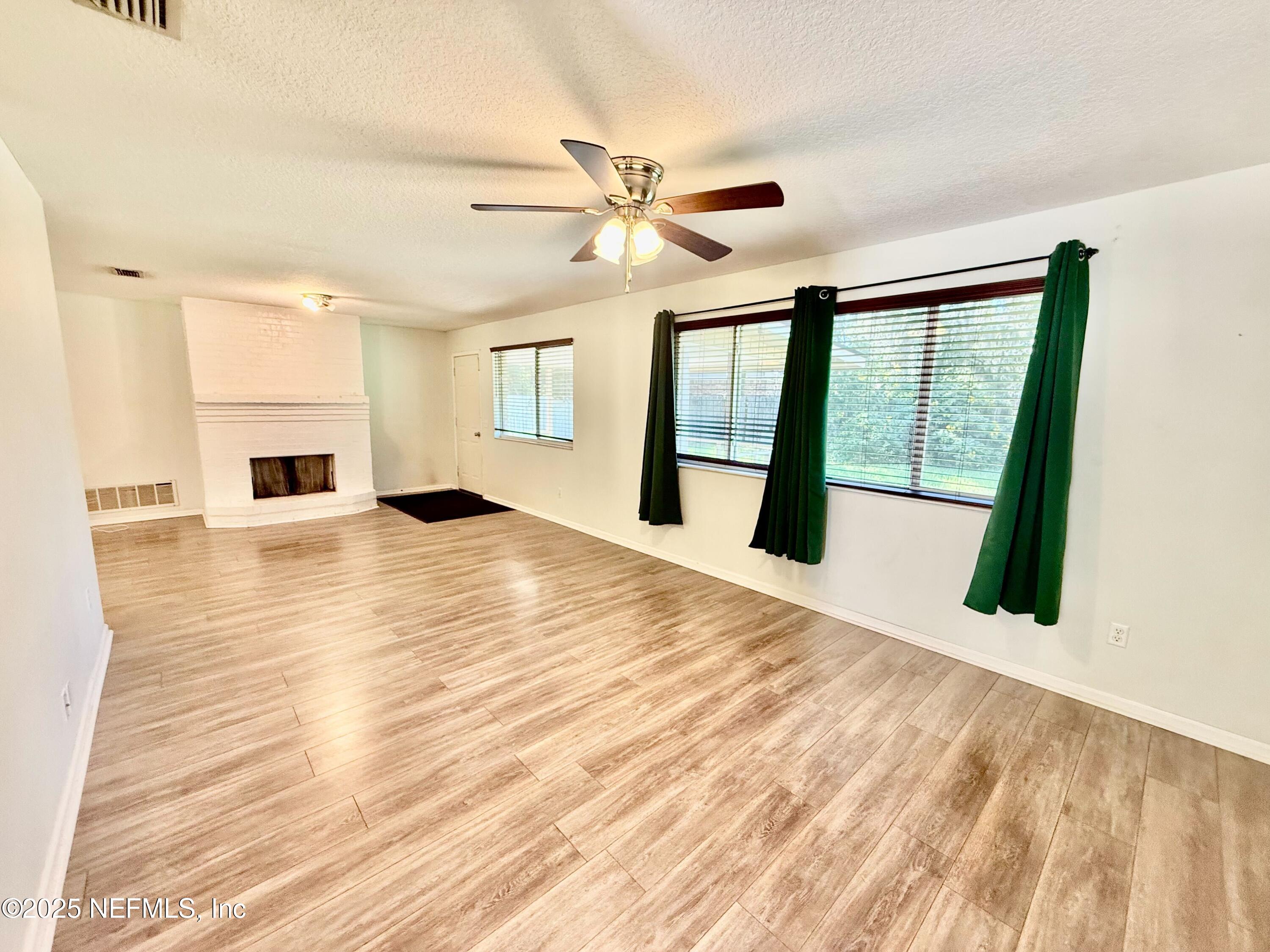 2349 Moody Avenue Orange Park, FL 32073 - Photo 5 of 10 a view of an empty room with wooden floor and a window