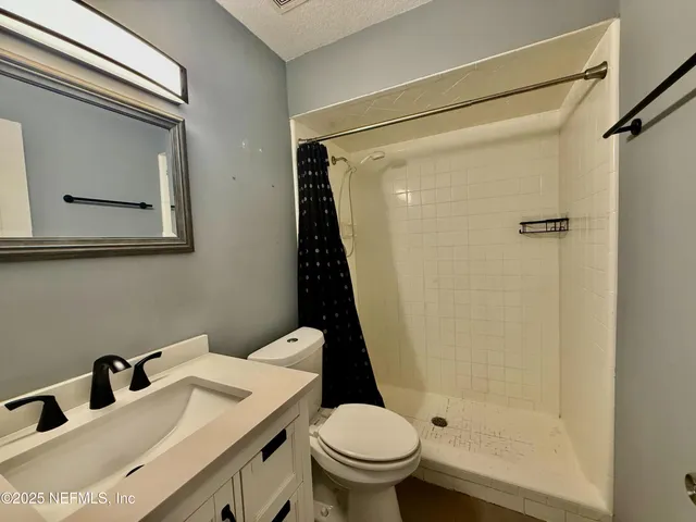 a bathroom with a sink mirror vanity and toilet