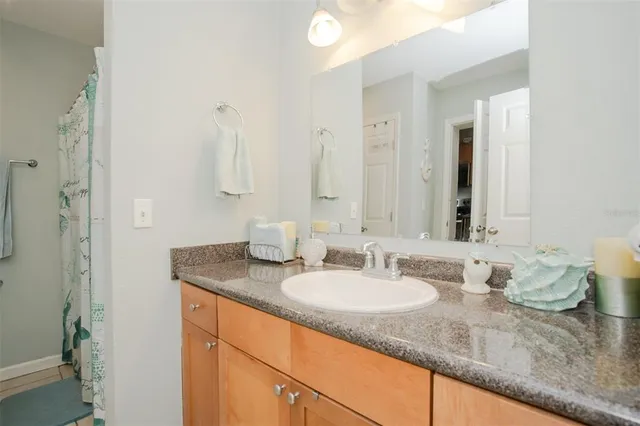 a bathroom with a granite countertop sink and a mirror