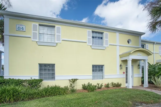 a front view of a house with plants and entryway