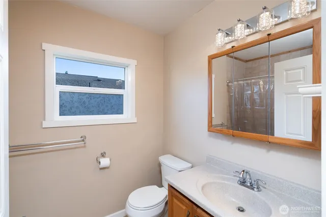 a bathroom with a toilet a sink and mirror