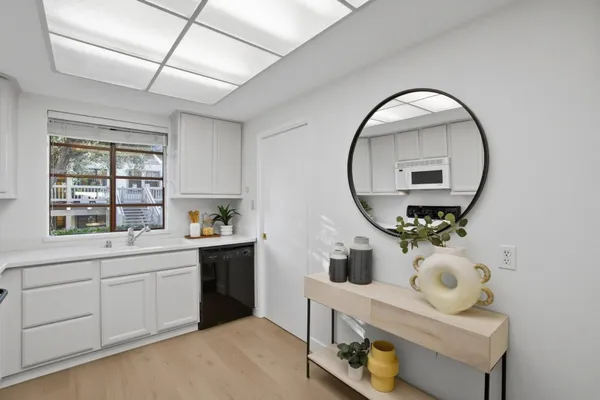 a room with round mirror and cabinets