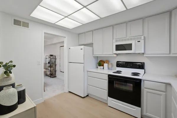 a kitchen with a refrigerator stove and white cabinets
