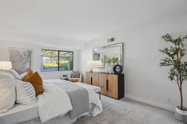 a bedroom with a large bed and a potted plant