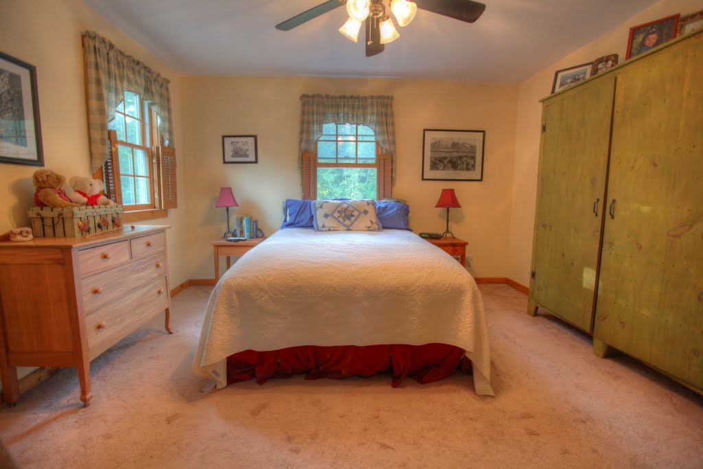 9 Stump Road Sandisfield, MA 01255 - Photo 27 of 29 a spacious bedroom with a bed and a chandelier