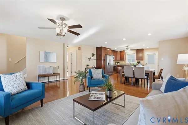 a living room with furniture kitchen view and a chandelier