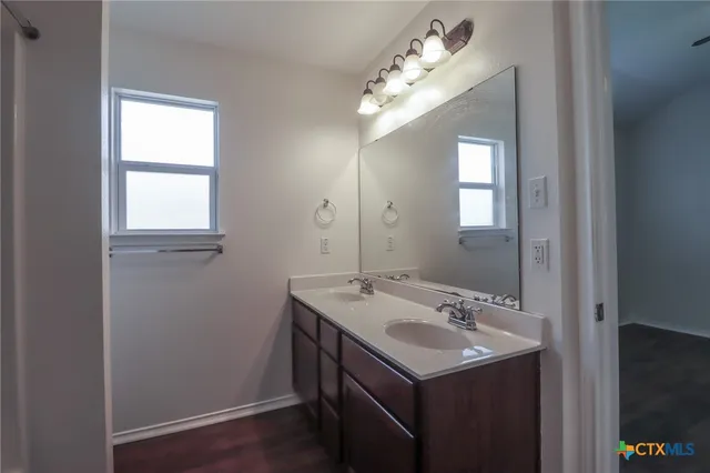 a bathroom with a sink a mirror and a window