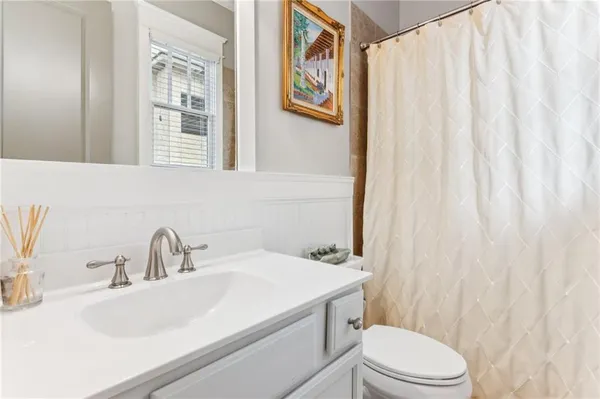 a bathroom with a sink and mirror with toilet