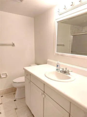 a bathroom with a sink a toilet and mirror
