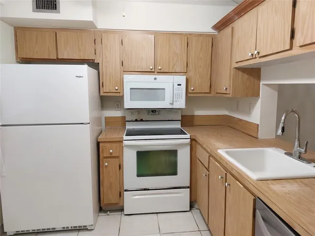 a kitchen with a sink a stove and a refrigerator