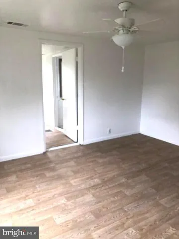 a view of empty room with window and fan