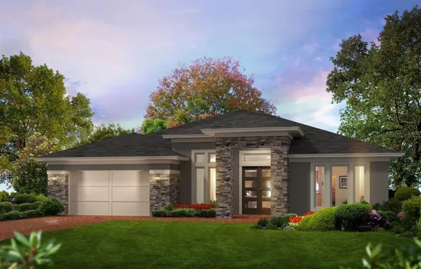 a front view of a house with a garden and plants