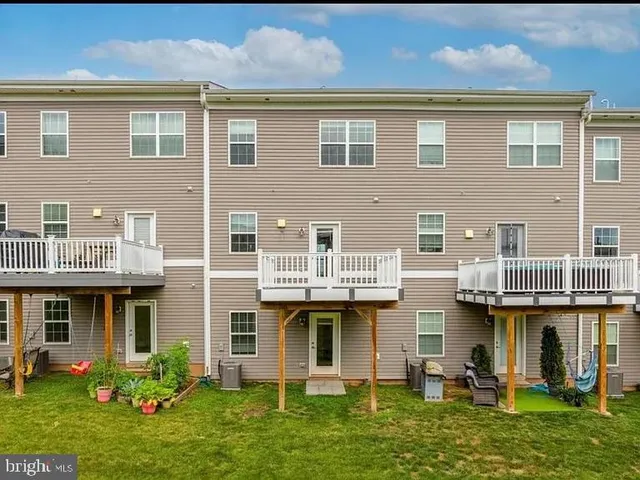 a front view of a residential apartment building with a yard