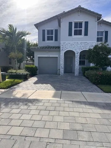 a front view of a house with yard and parking space