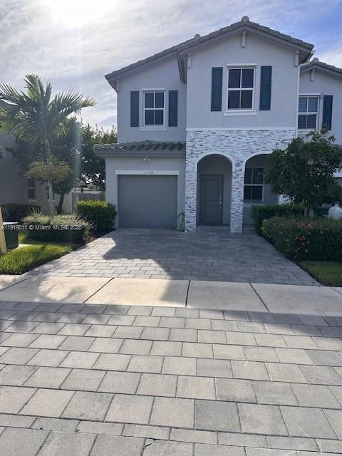 a front view of a house with yard and parking space