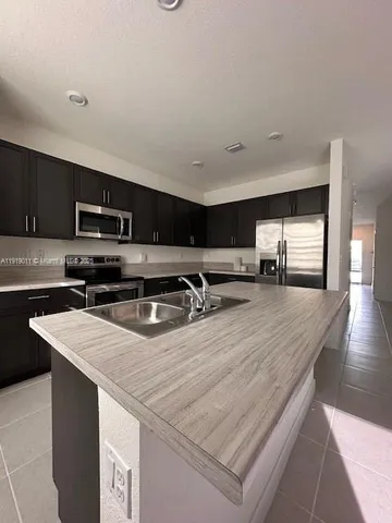 a kitchen with stainless steel appliances granite countertop a sink microwave and cabinets