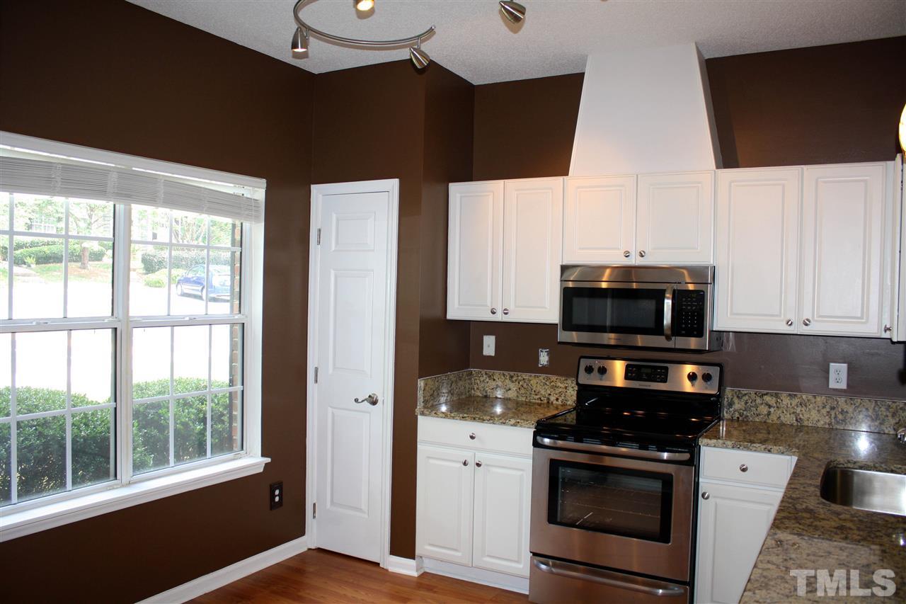 4435 Still Pines Drive Raleigh, NC 27613 - Photo 4 of 19 a kitchen with stainless steel appliances a stove microwave and sink