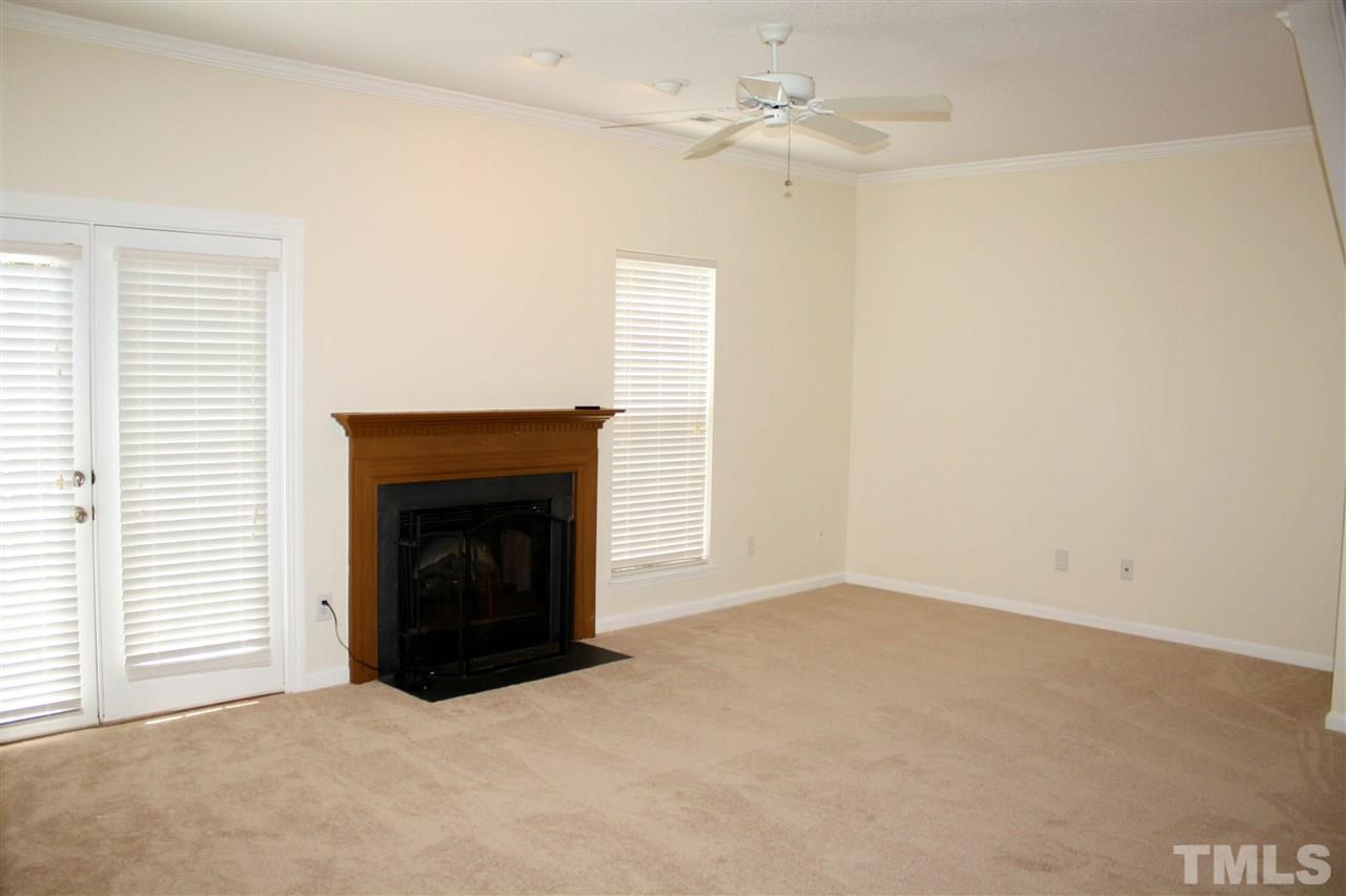 4435 Still Pines Drive Raleigh, NC 27613 - Photo 9 of 19 an empty room with a fireplace and fan