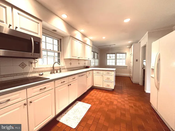 a kitchen with granite countertop white cabinets and white appliances
