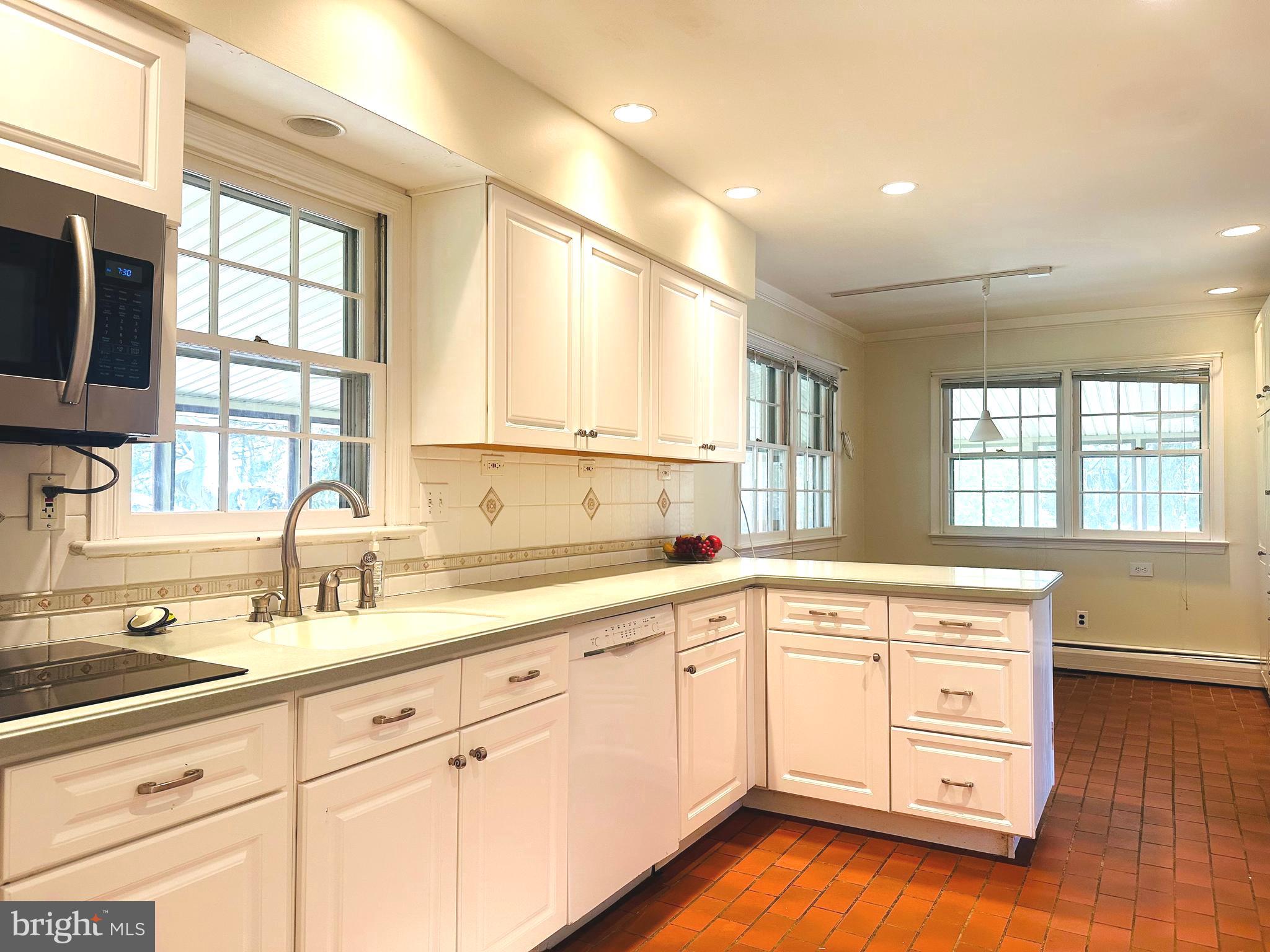 1626 Norristown Road Ambler, PA 19002 - Photo 29 of 57 a kitchen with a sink dishwasher a stove and white cabinets with wooden floor