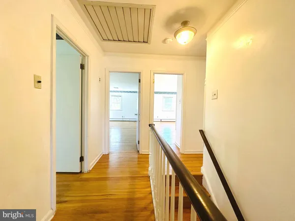 a spacious bedroom with a bed and wooden floor