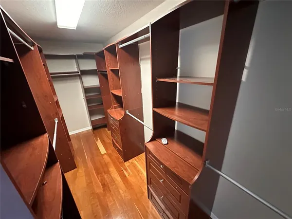 a view of walk in closet with clothes and shoes