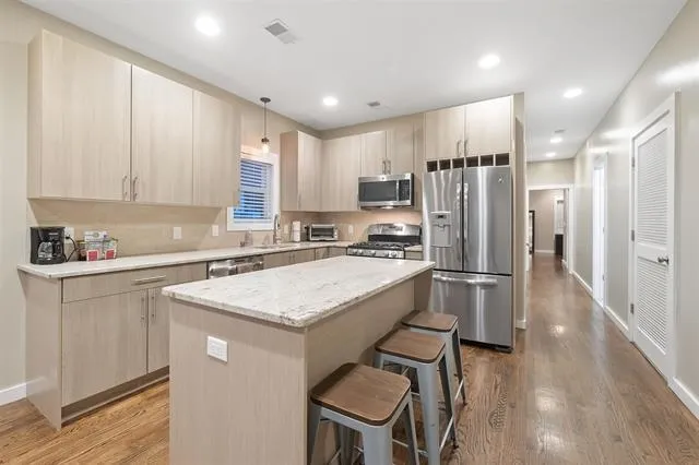 a kitchen with stainless steel appliances granite countertop a refrigerator a sink a stove a microwave and island