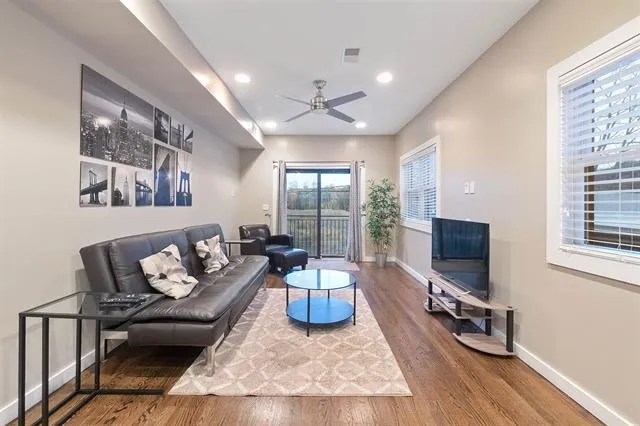 a living room with furniture a flat screen tv and a large window