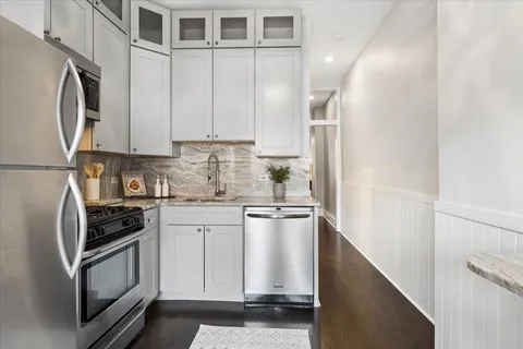 a kitchen with stainless steel appliances granite countertop a refrigerator sink and stove
