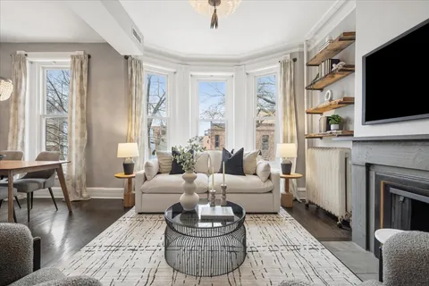a living room with furniture a flat screen tv and a fireplace